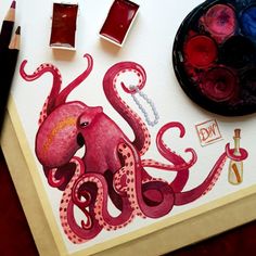 an octopus painting on paper with watercolors and paintbrushes next to it