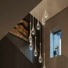 the modern chandelier is hanging from the ceiling above the stairs in this contemporary home