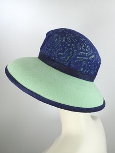 You'll look great in this pretty green and navy wool felt hat! It can easily transition from Winter to early Spring and is perfect for any dressy occasion. Imagine walking into church with this beauty! The flattering asymmetrical wide brim hat had a slight turned down brim with a cut out on the right side. It's topped with a gorgeous, extra wide ombre navy and green five loop bow that has a gorgeous Czech glass button in the center. This hat that will be the envy of everyone who sees it! The top Green Short Brim Felt Hat For Summer, Summer Green Felt Hat With Short Brim, Green Felt Hat With Curved Brim For Summer, Summer Green Felt Hat With Curved Brim, Green Summer Felt Hat With Curved Brim, Fitted Green Fedora For Kentucky Derby, Spring Fitted Green Fedora, Green Fedora Felt Hat For Spring, Green Fitted Felt Hat With Flat Brim