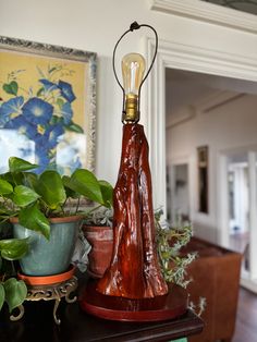 a lamp on top of a table next to potted plants