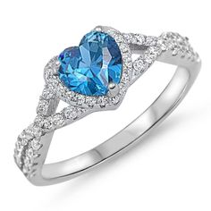 a heart shaped blue topazte and diamond ring with white diamonds on the sides