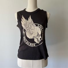 Rock Your Edgy Style With This Cool Graphic Tank Top From Chaser! This Black Sleeveless Top Features A Bold Front Graphic With A Skull And Wings, Accompanied By The Phrase “Live To Ride, Ride To Live,” Giving Off A Rebellious Biker Vibe. The Raw Edge Armholes Add To Its Laid-Back, Worn-In Look, Making It Perfect For Casual Wear, Concerts, Or Festivals. Made From Soft, Breathable Fabric, This Tank Is As Comfortable As It Is Stylish. Pair It With Jeans, Shorts, Or A Leather Jacket For An Effortles Skull And Wings, Black Sleeveless Top, Edgy Style, A Skull, Biker Style, Black Sleeveless, Festival Wear, Edgy Fashion, Raw Edge