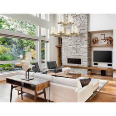 a living room filled with furniture and a flat screen tv mounted on a wall next to a fire place