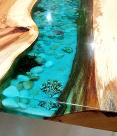 a close up of a wooden table with rocks and water in the bottom part of it