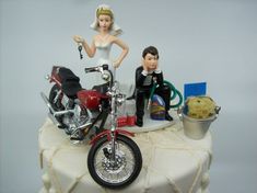 a wedding cake topper with a motorcycle and groom figurine sitting on it