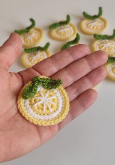 small crocheted fruit ornament being held by someone's left hand