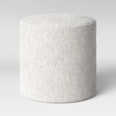 a white round ottoman sitting on top of a floor