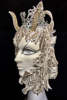 "Mab" is a spectacular interpretation of the proud and beautiful Elven Queen who surveys her domain from under her golden cornibus, and stunning crown of green rhinestones and Swarovski crystals and elements.  Her intricate silver and white embossed veil drips with pearl beading, rhinestones and Swarovski elements, as does her head covering which culminates in an exquisite rhinestone and Swarovski crystal central drape.  "Mab" will make a truly impressive  statement decor piece and is a one-off Face Decor, Elven Queen, Mask Venetian, White And Gold Decor, Black Wedding Gowns, Statement Decor, Costume Masks, Venetian Masks, Etsy Success