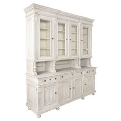 a white china cabinet with glass doors and drawers on the top, in front of a white background