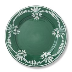 a green and white plate with flowers on the rim, in front of a white background