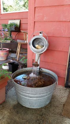 a bucket filled with water next to a red building