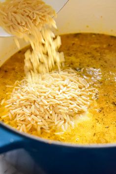 someone is pouring rice into a pot of broth