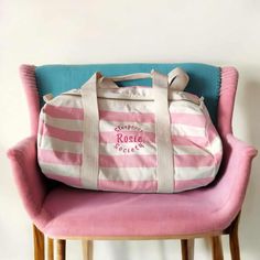 a pink and white striped bag sitting on top of a chair next to a wall