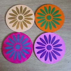 three different colored paper plates sitting on top of a wooden table next to each other