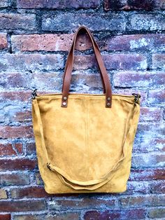 Tote suede leather bag in MUSTARD YELLOW. Natural genuine suede leather. Yellow large boho bag. Closed by a zipper, with shoulder straps and removable cross body adjustable straps. The inside of the bag is fully lined in a cotton/nylon strong fabric. We added a small leather pouch on the inner part of the bag and a zipper clised pocket aswell. You can easily carry your books, laptop or tablet in one nice bag , made of soft suede leather Width upper part: 42 cm - 16 inch Height: 38 cm - 15 inch b Suede Shoulder Bag With Adjustable Strap For On-the-go, Yellow Leather Shoulder Bag For On-the-go, Large Capacity Suede Shoulder Bag For Everyday Use, Suede Shoulder Bag With Leather Lining, Large Capacity Suede Shoulder Bag With Double Handle, Large Capacity Double Handle Suede Shoulder Bag, Yellow Leather Hobo Bag For Everyday Use, Suede Hobo Tote Bag For Everyday Use, Daily Suede Satchel With Soft Leather