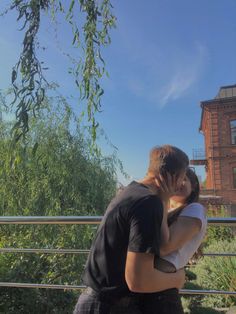 two people standing next to each other on a bridge