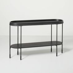 a black table with two shelves on each side and one shelf below it, against a white background