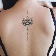 a woman's back with a lotus tattoo on it