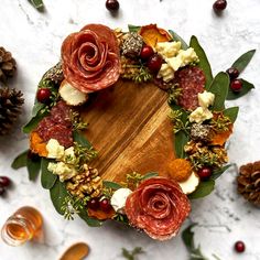 a wreath made out of meats, cheese and leaves on top of a table