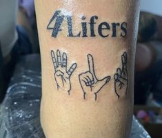 a person with a tattoo on their leg that says 4lifers and five fingers