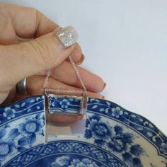 a person holding onto a blue and white plate with a ring on it's finger