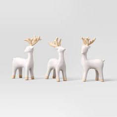 three small white deer figurines sitting next to each other