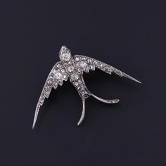 Antique Diamond Swallow Brooch: This antique swallow brooch dates to the late Victorian era (circa 1980).  The brooch is silver topped 14k gold and studded with old cut diamonds.  The piece measures 1.1 inches by 1.7 inches wide. It weighs 6.40 grams and is in great condition. Upon purchase, your brooch will arrive elegantly packaged, ready for gifting or as a special treat for yourself.  We carefully wrap each piece to ensure a delightful unboxing experience. We also offer free and flexible layaway plans, so take advantage of this option to make owning your dream piece even more achievable. + Trademark Antiques Shop Homepage https://www.etsy.com/shop/TrademarkAntiques + Our Store Policies https://www.etsy.com/shop/TrademarkAntiques/policy?ref=shopinfo_policies_leftnav + Connect with us on Antique Diamond Brooches As Gifts, Ornate Diamond Brooch As Gift, Antique Diamond Brooch For Gift, Swallow Bird Jewelry, Victorian Gold Diamond Brooches, Unboxing Experience, Silver Tops, Antique Diamond, Antique Shops