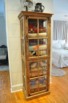 a wooden cabinet filled with lots of blankets