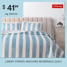 a bed with blue and white striped bedspread next to a nightstand in a bedroom