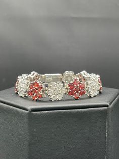 This is a beautiful natural garnet and cubic zirconia sterling silver floral bracelet. This bracelet features natural garnet and CZ stones that form a pattern of flowers.  This bracelet is 8 inches long. This bracelet weighs a hefty 29.29 grams. Garnet is the gemstone associated with January. This bracelet is very well made and would be a great gift for a special someone. This item is new and unworn. Formal Multi-stone Cubic Zirconia Tennis Bracelet, Silver Multi-stone Tennis Bracelet For Formal Occasions, Formal Multi-stone Flower-shaped Jewelry, Elegant Silver Multi-stone Diamond Bracelet, Elegant Sterling Silver Multi-stone Bracelet For Formal Occasions, Elegant Multi-stone Silver Diamond Bracelet, Elegant Red Flower Bracelets, Elegant Red Flower Bracelet, Elegant Silver Tennis Bracelet With Ruby