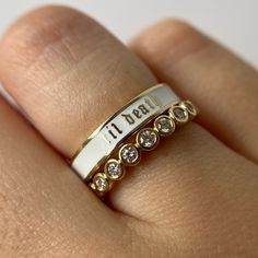 a close up of a person's hand wearing a ring with diamonds on it