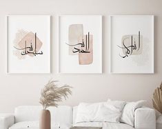 three framed art pieces hang on the wall above a white couch in a living room