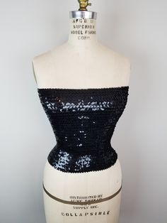 Classic Black Sequin Fitted Stretch Strapless Bandeau Tube Top * Cocktail Party  Great all by itself or layered under a blouse with plunging neckline for a bit of sparkle, pair under a kimono or jacket, etc. One Size Width 24"~36" Length 11 1/2" Pull on fit Fabric does have stretch 95% Acrylic 5% Spandex Hand wash cold, line dry Excellent Condition Evening Bandeau Fitted Corset, Fitted Bandeau Corset For Evening, Sequined Evening Crop Top For Party Season, Glamorous Sequined Evening Crop Top, Evening Sequined Crop Top For Party Season, Glamorous Evening Corset With Sequins, Glamorous Stretch Tube Top For Evening, Strapless Sequined Corset For Prom, Fitted Strapless Crop Top For Evening