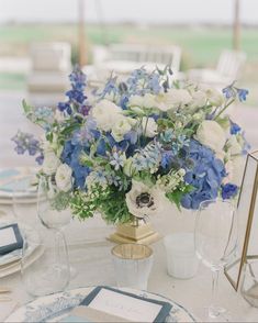 a vase filled with blue and white flowers sitting on top of a dining room table