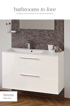 a white bathroom vanity sitting on top of a wooden floor next to a tiled wall