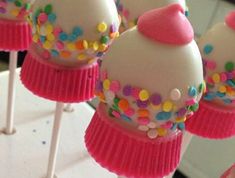 cake pops decorated with sprinkles and pink frosting are on a stick