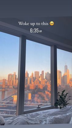 a bedroom with a view of the city from it's window sill and bed