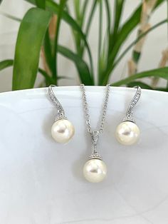 Simple Elegant and chic, Swarovski pearl jewelry earrings, perfect gift for your bridesmaids! The  earrings very comfortable on the ears you will love them! I made them using 10mm round Swarovski Pearls . white/ivory, cream, and grey available. The earrings are very lightweight and come with cubic zirconia embellished ear wires. They measure about 1" in length.  matching necklace available too. the necklace is 18" long chain plus 2" extension. Rhodium is the most expensive precious metal and is Elegant Pearl Embellished Jewelry Sets For Formal Occasions, Elegant Jewelry Sets With Pearl Pendant For Gift, Elegant Pearl Drop Jewelry Set, Elegant Pearl Jewelry Set With Pearl Drop, Elegant Pearl Dangle Jewelry Set, Pearl Bridal Earrings With Pearl Pendant, Elegant Bridal Earrings With Pearl Pendant, Elegant Bridal Earrings With Pearl Pendant As Gift, Pearl White Bridal Earrings With Pearl Pendant As Gift