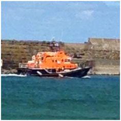 an orange and black boat in the water