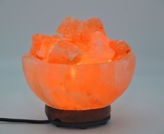 an orange himalayan salt lamp on a wooden stand