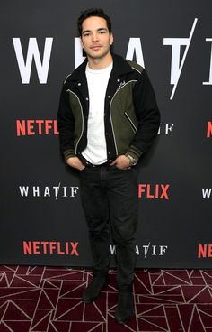 a man standing in front of a black and red wall with the netflix logo on it