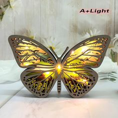 a light that looks like a butterfly is sitting on a table with flowers in the background