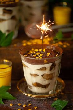 a cup filled with ice cream covered in chocolate and topped with a small sparkler