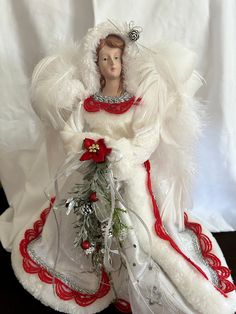 an angel figurine is dressed in white and red