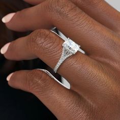 a woman's hand with a diamond ring on her finger and an engagement band