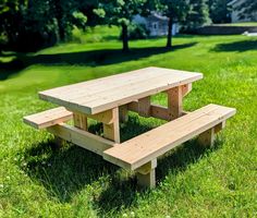 a wooden picnic table sitting in the grass