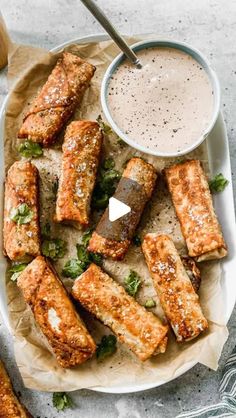 grilled tofu sticks on a plate with dipping sauce and garnishes