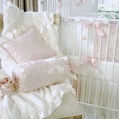 a baby crib with pink and white bedding