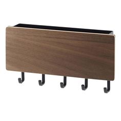 a wooden wall mounted shelf with three black hooks on the bottom and one brown coat rack above it