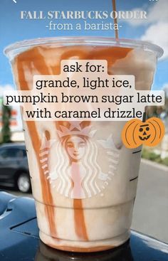 a cup of coffee sitting on top of a table next to a sign that reads, ask for pumpkin brown sugar latte with caramel drizle